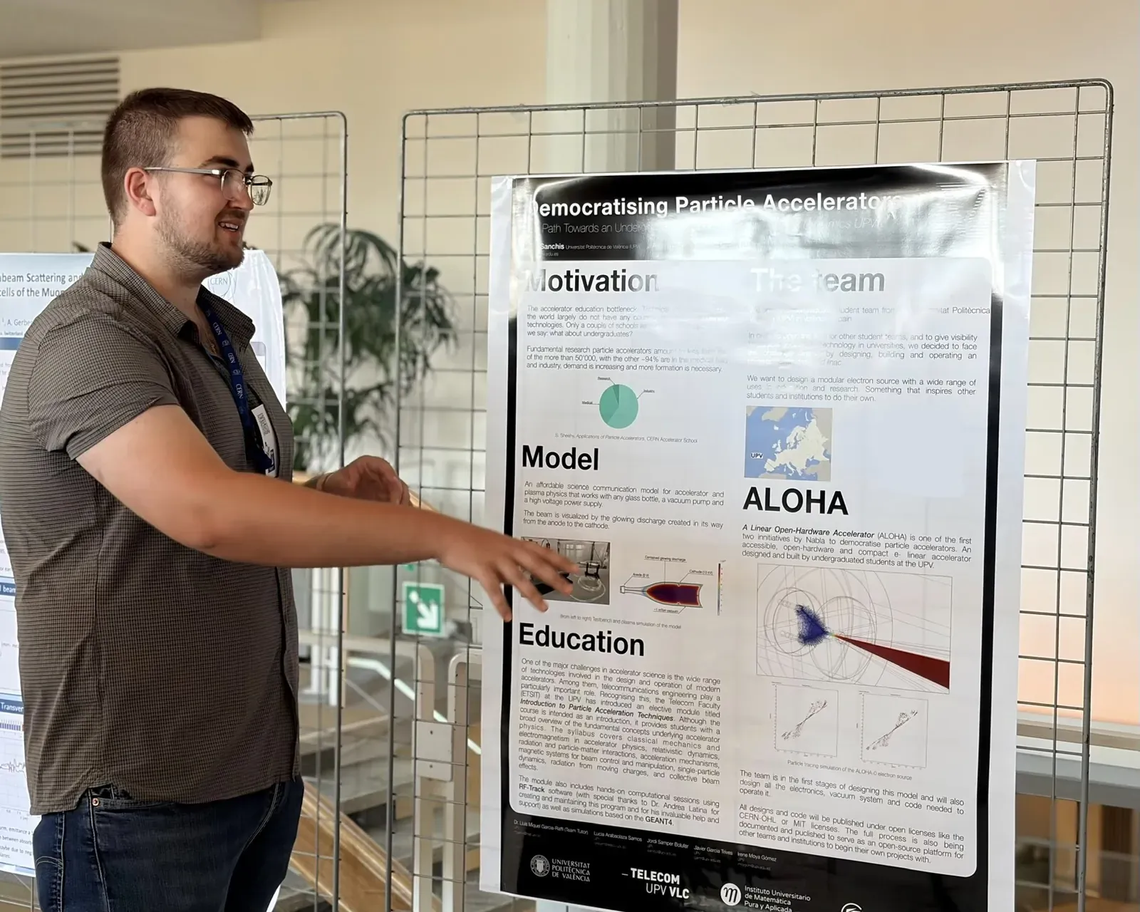 A team member presents the poster Democratising Particle Accelerators at the poster session at CERN.