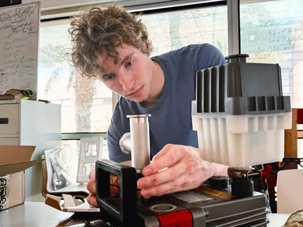 A team member at work on the vacuum pump of the bench.